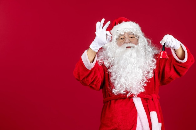 Vorderansicht Weihnachtsmann hält kleine Glocke auf rotem Geschenk Emotionen Weihnachten Urlaub Neujahr