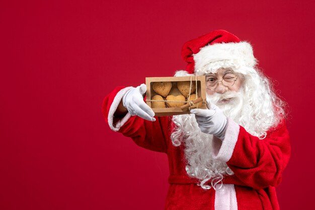 Vorderansicht weihnachtsmann hält paket mit keksen