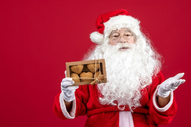 Vorderansicht weihnachtsmann hält paket mit keksen
