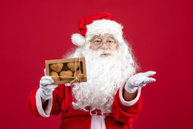 Vorderansicht weihnachtsmann hält paket mit keksen
