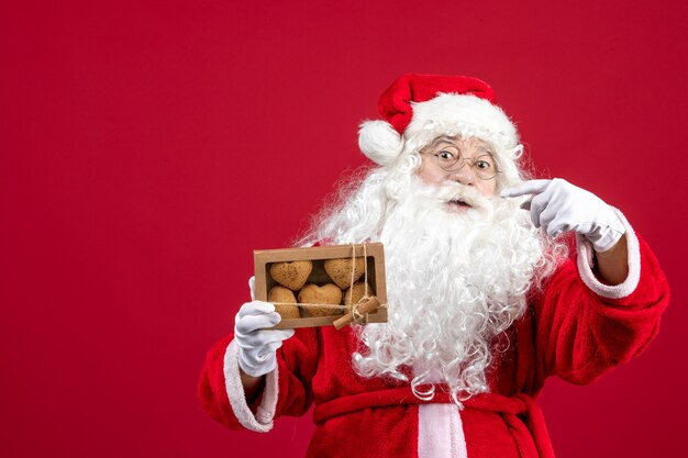 Vorderansicht weihnachtsmann hält paket mit keksen