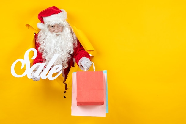 Vorderansicht weihnachtsmann hält verkaufsschrift und pakete