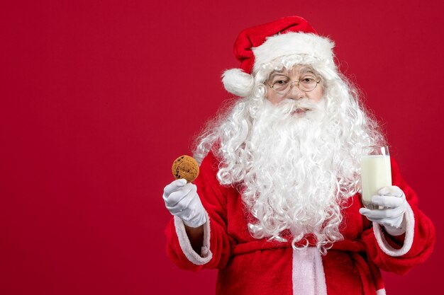 Vorderansicht weihnachtsmann isst kekse und trinkt milch