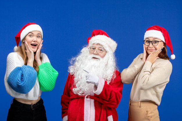 Vorderansicht weihnachtsmann mit frauen auf blauem kaltem urlaub weihnachten neues jahr