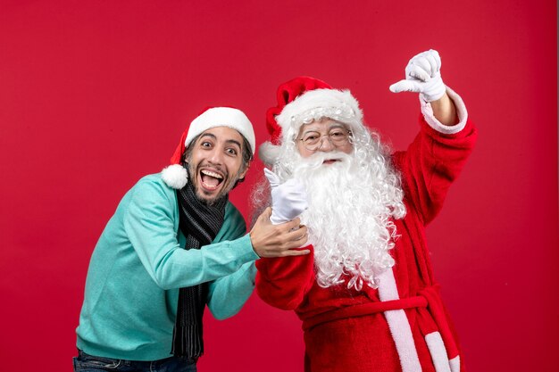 Vorderansicht Weihnachtsmann mit jungem Mann gerade stehend