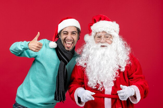 Vorderansicht Weihnachtsmann mit jungem Mann gerade stehend