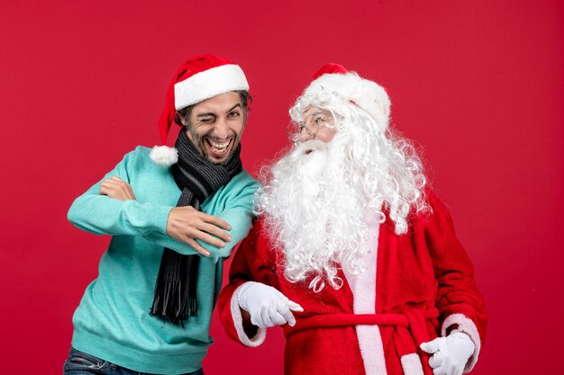 Vorderansicht Weihnachtsmann mit jungem Mann gerade stehend