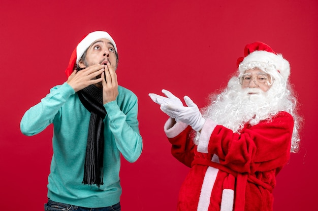 Vorderansicht Weihnachtsmann mit jungem Mann gerade stehend