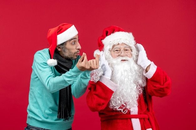 Vorderansicht Weihnachtsmann mit jungem Mann gerade stehend