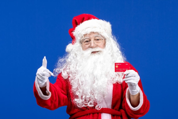 Vorderansicht weihnachtsmann mit roter bankkarte auf dem blauen weihnachtsgeschenk des neuen jahres