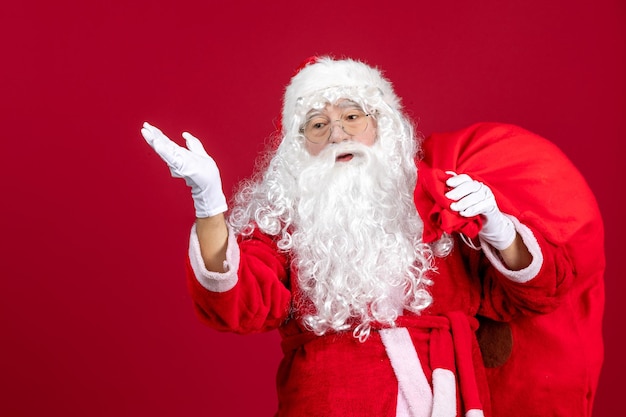 Vorderansicht weihnachtsmann mit tüte voller geschenke auf dem roten emotion urlaub neues jahr weihnachten