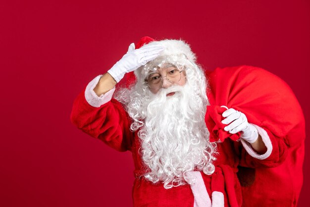 Vorderansicht weihnachtsmann mit tüte voller geschenke auf dem roten emotion urlaub neues jahr weihnachten