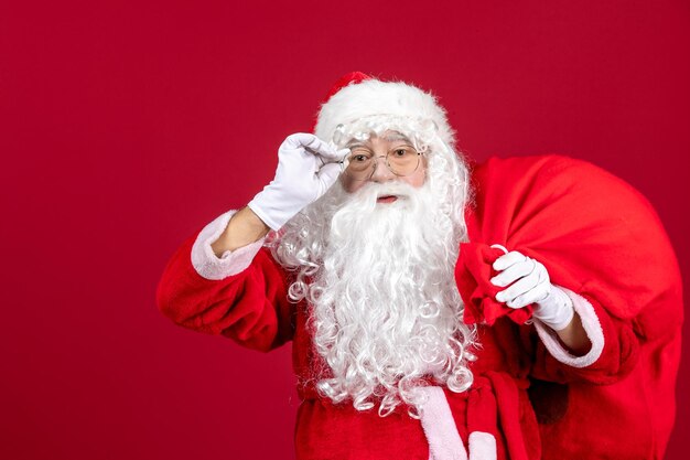 Vorderansicht weihnachtsmann tragetasche voller geschenke auf rotem emotion urlaub neues jahr weihnachten