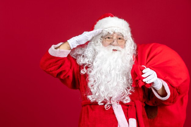 Vorderansicht Weihnachtsmann Tragetasche voller Geschenke auf roten Emotionen Urlaub Neujahr Weihnachten