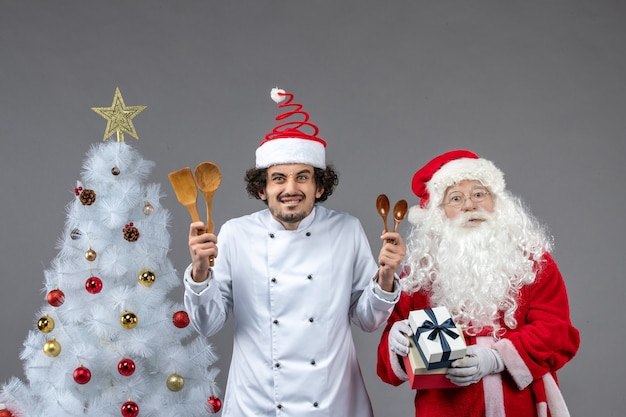 Vorderansicht Weihnachtsmann um Urlaubsattribute mit männlichem Koch
