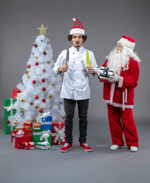 Vorderansicht weihnachtsmann um weihnachtsgeschenke mit männlichem koch