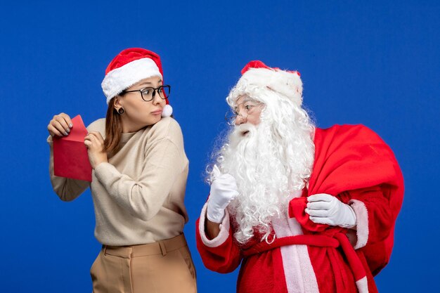 Vorderansicht Weihnachtsmann und junger weiblicher Eröffnungsbrief auf blauem Feiertagsgefühl Weihnachten neues Jahr