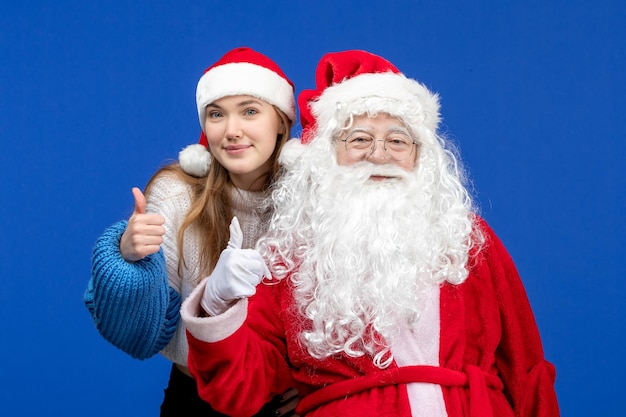 Vorderansicht weihnachtsmann zusammen mit junger frau auf blauer menschlicher weihnachtsfarbe neues jahr