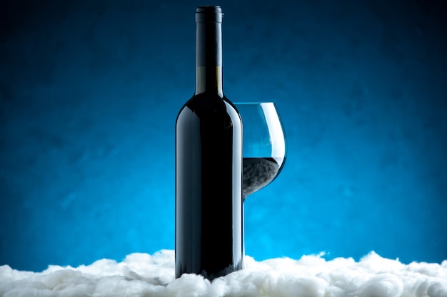 Vorderansicht Weinglas und Flasche auf blauem Hintergrund