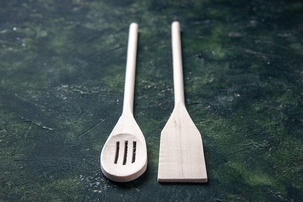 Vorderansicht weiße Plastikutensilien auf dunklem Boden Plastikgabelbesteck Holzmesser Küche Essen Foto