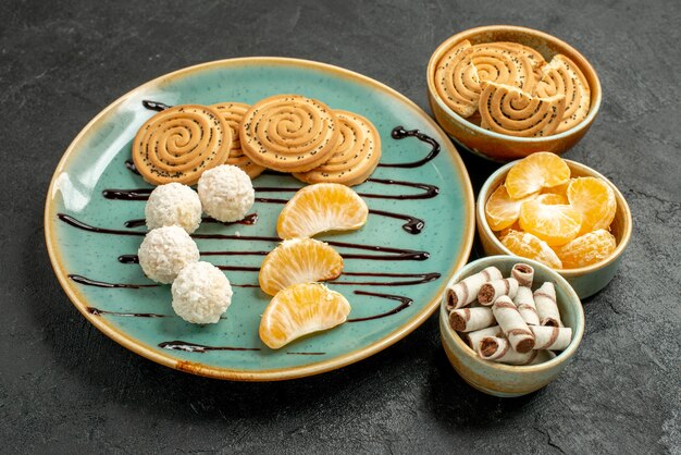 Vorderansicht-Zuckerplätzchen mit Kokosnussbonbons auf dem grauen Tischkeksplätzchen süß