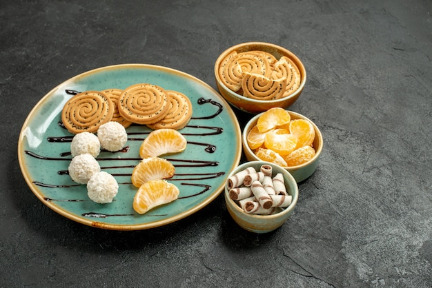 Vorderansicht-Zuckerplätzchen mit Kokosnussbonbons auf dem grauen Tischkeksplätzchen süß