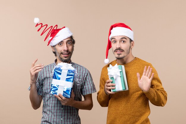 Vorderansicht zwei gewanderte Jungs, die ihre Hände halten und Weihnachtsgeschenke halten