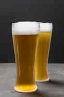 Kostenloses Foto vorderansicht zwei gläser mit dem bier, das schaum hat