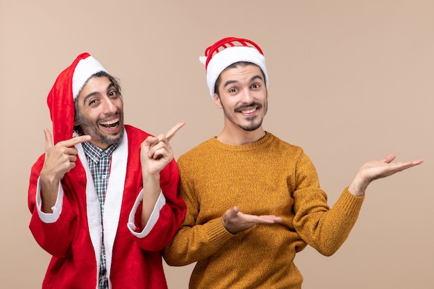 Vorderansicht zwei Männer, die beide etwas auf beigem isoliertem Hintergrund zeigen