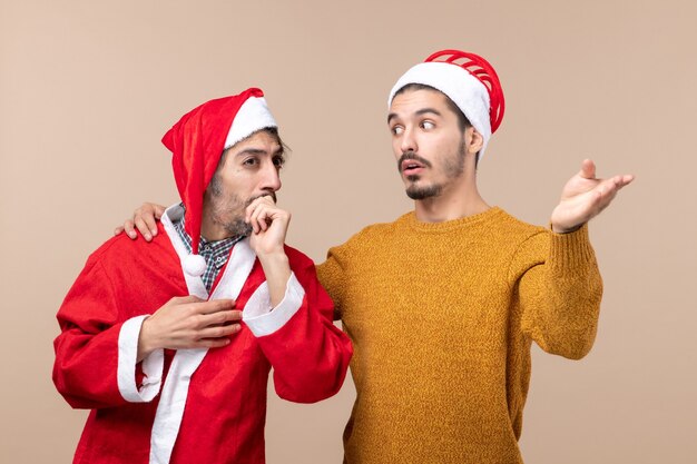 Vorderansicht zwei Männer, die etwas zu einem anderen auf beigem isoliertem Hintergrund zeigen