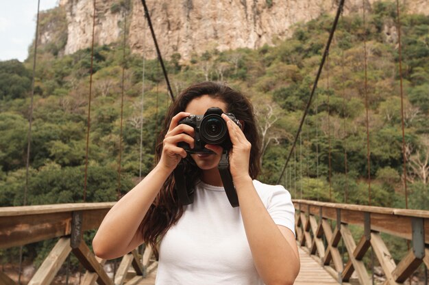 Vorderansichtfrau auf der Brücke, die Fotos macht