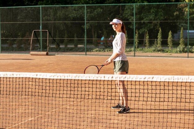 Kostenloses Foto vorderansichtfrau auf tennisplatz