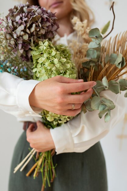 Vorderansichtfrau, die Blumen hält