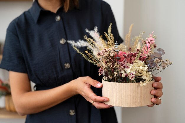 Vorderansichtfrau, die Blumen hält