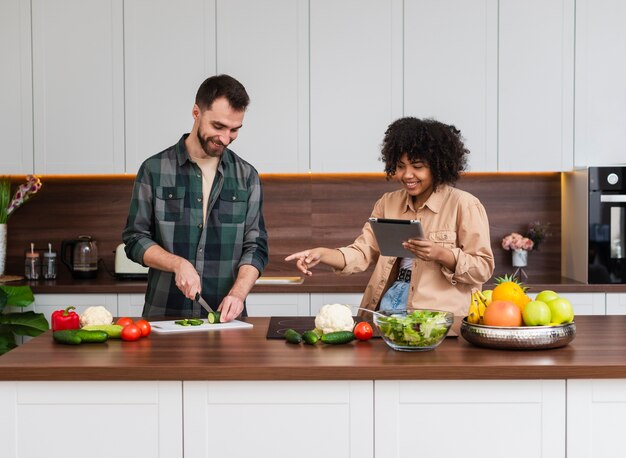 Vorderansichtfrau, die das Mannkochen betrachtet