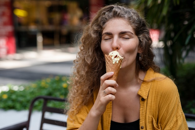 Kostenloses Foto vorderansichtfrau, die eiscreme isst