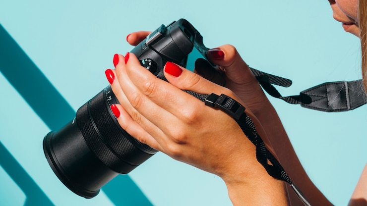 Kostenlose Foto vorderansichtfrau, die fotos auf kamera überprüft