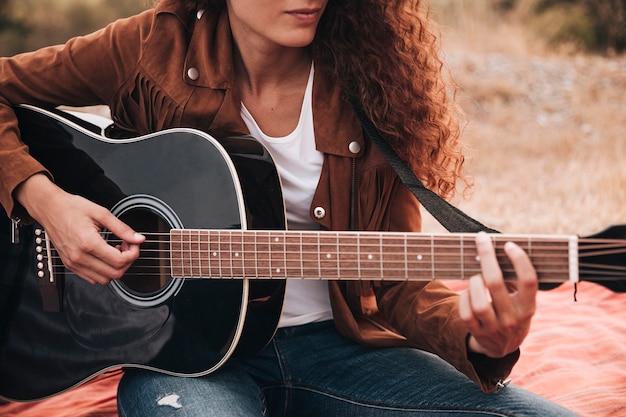 Kostenloses Foto vorderansichtfrau, die gitarre spielt