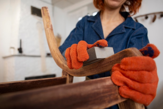 Kostenloses Foto vorderansichtfrau, die holzmöbel wieder herstellt