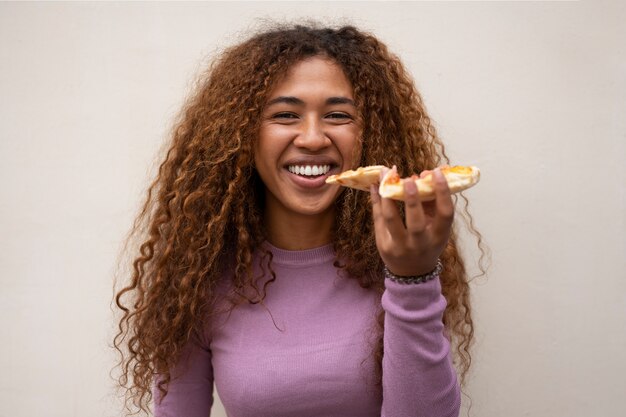 Vorderansichtfrau, die köstliche Pizza isst