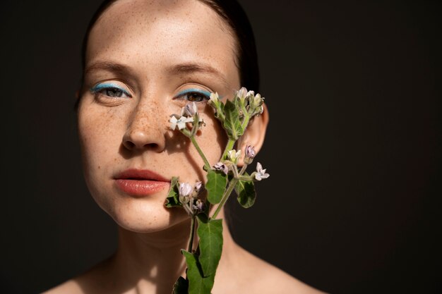 Vorderansichtfrau, die mit Blume aufwirft