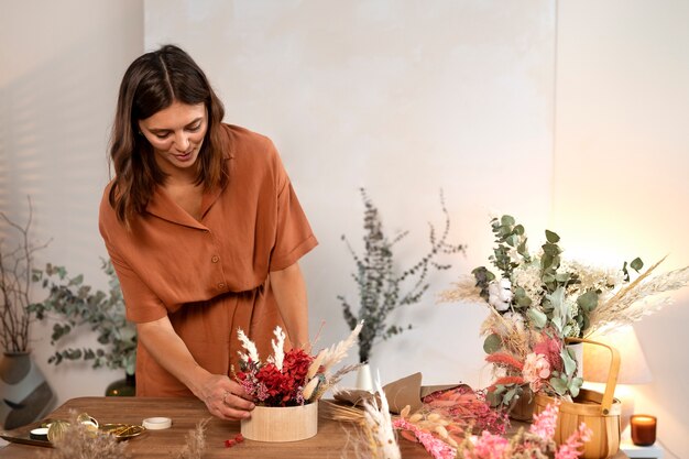 Vorderansichtfrau, die mit Blumen arbeitet