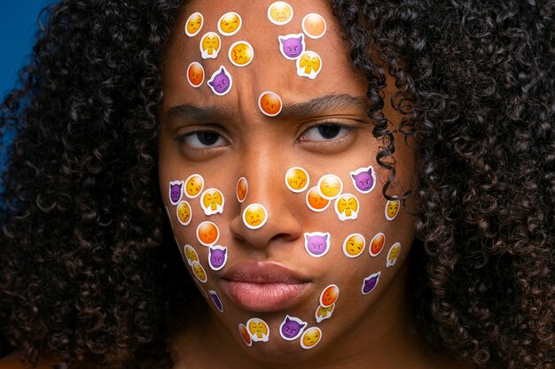 Vorderansichtfrau, die mit Emojis auf Gesicht aufwirft