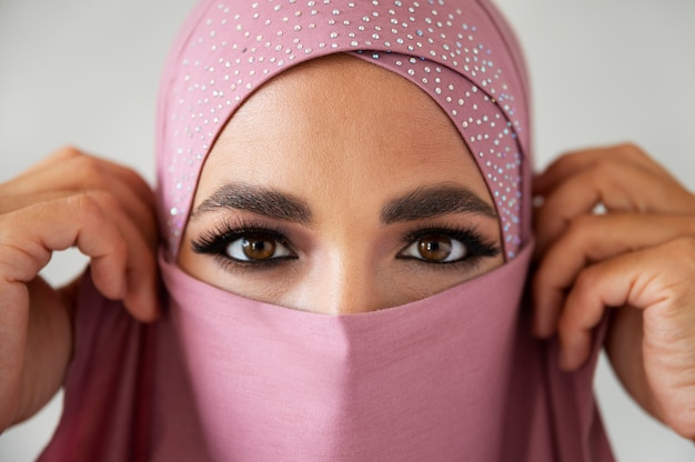 Vorderansichtfrau, die mit rosa Hijab aufwirft