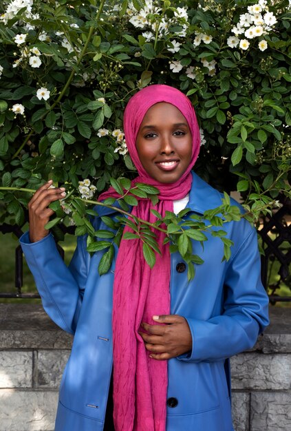 Kostenloses Foto vorderansichtfrau, die mit schönen blumen aufwirft