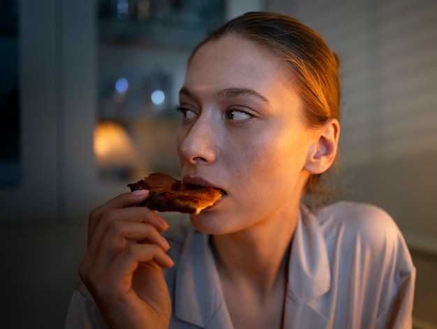 Vorderansichtfrau, die nachts Snacks isst