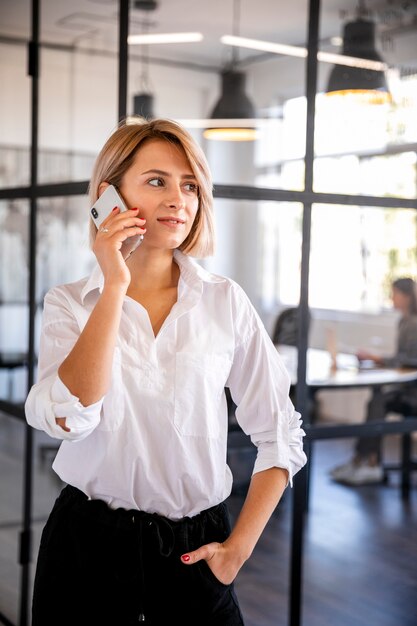 Vorderansichtfrau, die über Telefon spricht