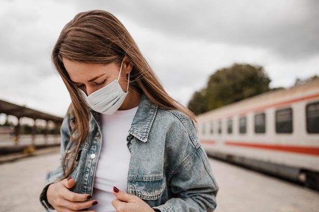 Kostenloses Foto vorderansichtfrau, die unten auf den bahnhof schaut