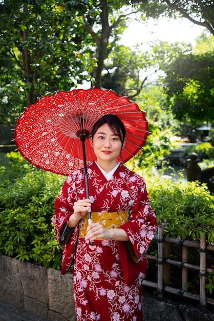Vorderansichtfrau, die wagasa-regenschirm hält
