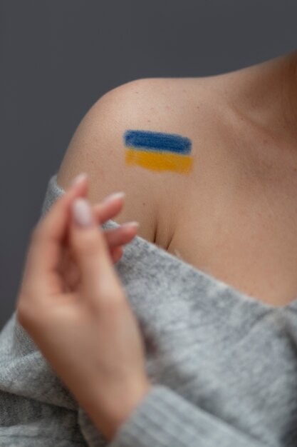 Vorderansichtfrau mit gemalter ukrainischer Flagge